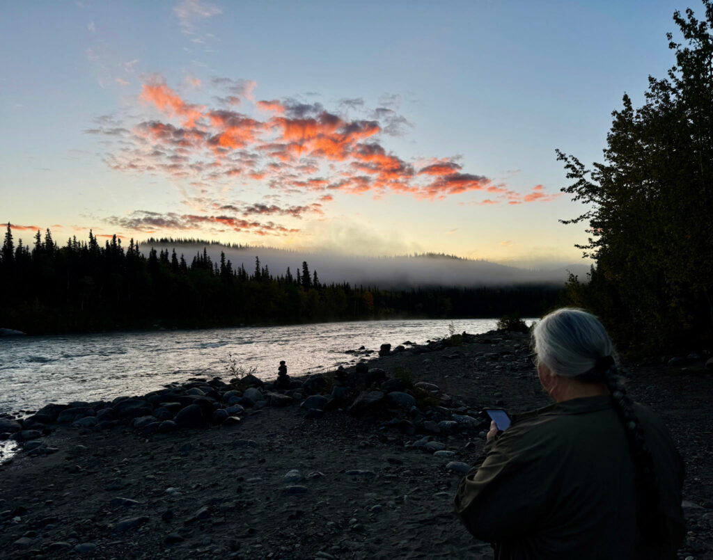 Nenana River in Alaska at Dawn. White-haired woman praying.