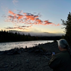 Nenana River in Alaska at Dawn. White-haired woman praying.